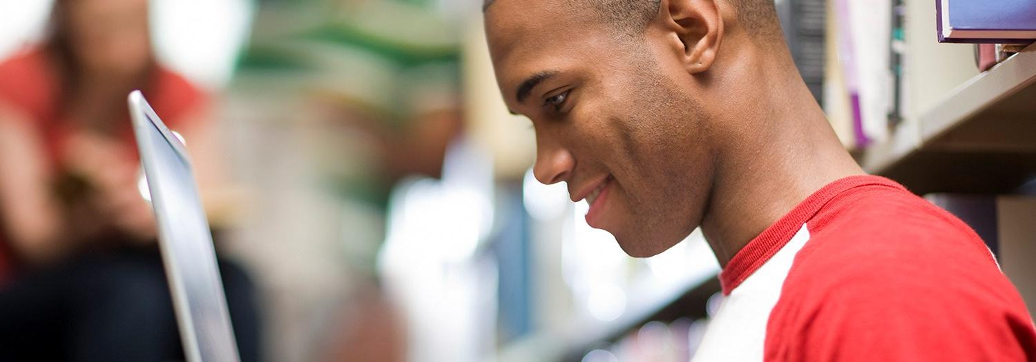 Male student looking at a laptop screen